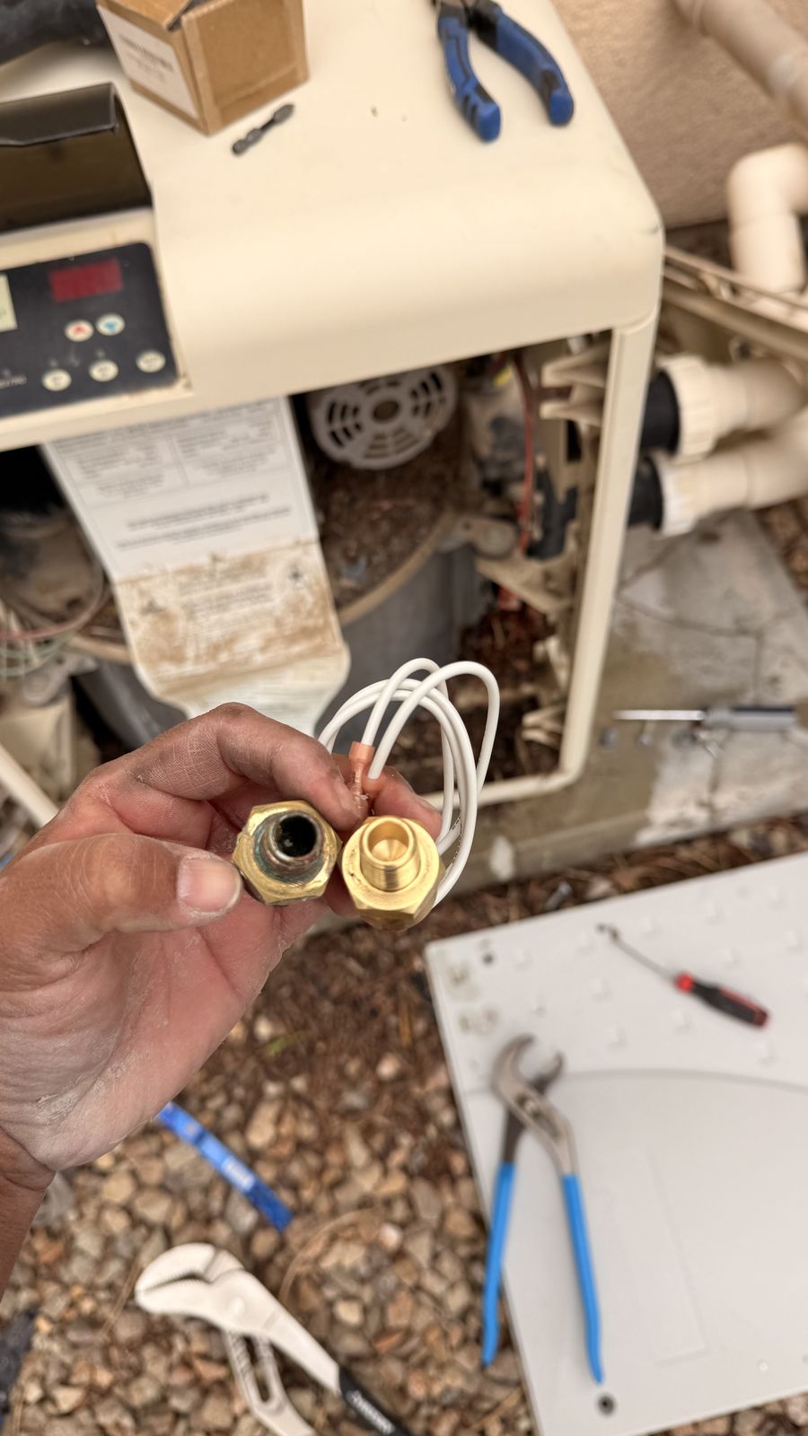 Scaled brass heater fitting next to a new replacement